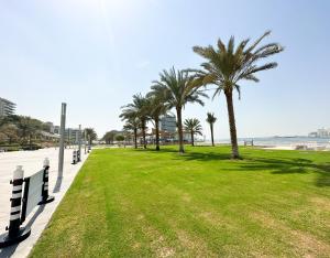 阿布扎比Paradis De La Mer Al Zeina 507A1的海滩上种有棕榈树的公园