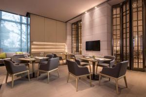 青浦Courtyard by Marriott Shanghai Hongqiao的餐厅设有桌椅和平面电视。