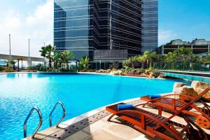 深圳深圳大中华喜来登酒店的一座带椅子的大型游泳池和一座建筑
