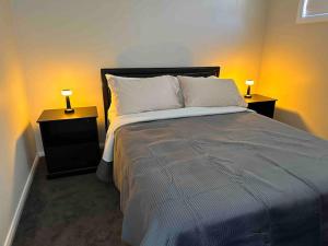 KingswoodGranny Guest house Sydney Blue Mount的一间卧室配有一张带2个床头柜的大床