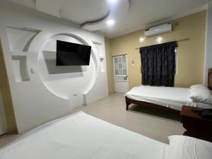 HuaquillasHotel SMIR的一间卧室配有一张床和一台平面电视