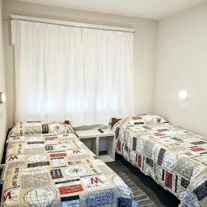 布拉加多Hotel Miceli的客房设有两张床和窗户。