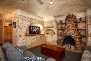 库伯佩迪盯奇迪杜古度假屋的客厅设有带壁炉的石墙