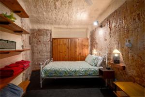 库伯佩迪盯奇迪杜古度假屋的卧室配有一张石墙床