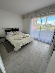 圣西普里安Saint Cyprien Golf View 2 bedrooms Apartment , 900 m from the beach的一间卧室设有一张床和一个大窗户