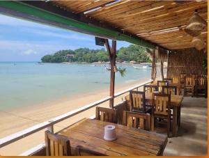 普吉镇Comfy 2-King Bed Condo - 3 Min to Rawai Beach at The Titile V Condo's的海滩上带桌椅的餐厅