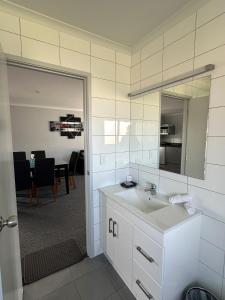 奥波蒂基Eastland Pacific Motor Lodge的一间带水槽和镜子的浴室以及一间用餐室
