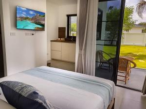 蔻立Bungalow Khao Lak的一间卧室配有一张床,墙上配有电视
