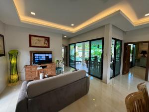 拉威海滩Nenuphar Villa by G Estate的带沙发和电视的大型客厅