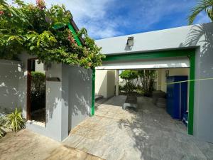 拉威海滩Nenuphar Villa by G Estate的白色的房子,设有绿色和白色的车库