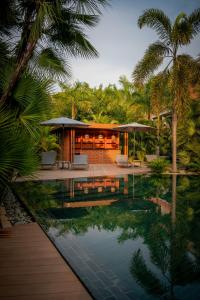 暹粒Angkor Grace Residence & Wellness Resort的一座带游泳池和棕榈树的房子