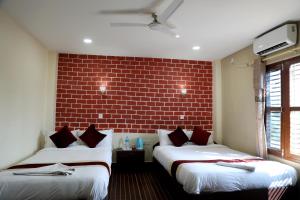 索拉哈Hotel Vista Chitwan的砖墙客房的两张床