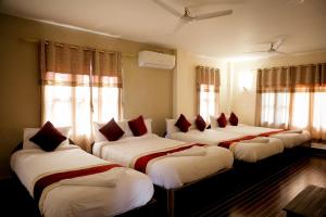 索拉哈Hotel Vista Chitwan的窗户间内的四张床