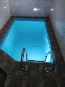 波尔塔瓦Нова квартира的浴室里设有蓝色灯光的游泳池