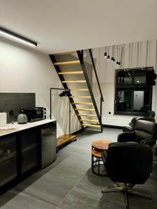 格但斯克Motława Riverside Apartments的客厅设有楼梯和桌椅