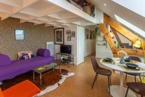 亚眠un Nid en Ville -Amiens Centre ville avec Parking的客厅配有紫色沙发和桌子