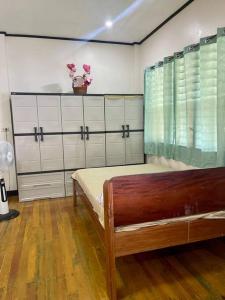 马斯巴特Maria Kulafu Kubo House 1 BIG BEDROOM with Wifi的一间卧室,配有一张床和一堆衣架