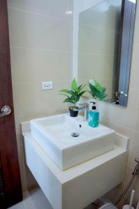 长滩岛L'eau Bleue Boracay Condotel的浴室设有白色水槽和镜子