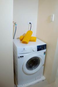 长滩岛L'eau Bleue Boracay Condotel的洗衣机的顶部配有黄色毛巾