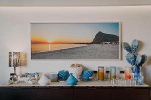 圣维托罗卡波皮克罗蒙德酒店的一张带蓝色花瓶的桌子和墙上的一张照片