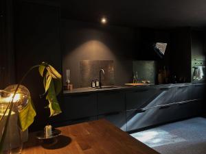 莫伦莱克The Lodge的厨房配有黑色橱柜、水槽和桌子