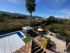 穆尔西亚CHALET EN MURCIA con piscina de verano y spa a 36 grados的享有棕榈树游泳池的景色