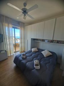 圣雷莫Il Paradiso del Relax Chambres d'hotes Affittacamere room with sea view的卧室内的一张大床,配有吊扇