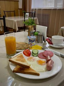 阿斯塔纳Belon Land的早餐盘包括鸡蛋香肠、烤面包和一杯橙汁