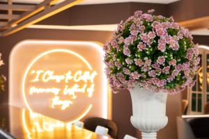 曼谷Siri Grand Bangkok Hotel的白色花瓶,上面有粉红色的花朵