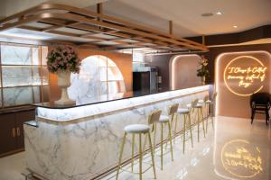 曼谷Siri Grand Bangkok Hotel的一个带大理石柜台和凳子的酒吧