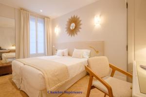 巴黎Hotel Boileau的卧室配有白色的床和椅子