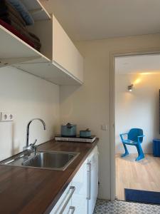 IlpendamZelfstandig appartement - 10 minuten tot Amsterdam的厨房配有水槽和蓝色椅子