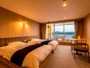 白滨Yukai Resort Premium Shirahama Gyoen的酒店客房设有两张床和窗户。