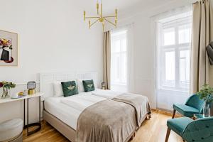 布达佩斯House Beletage-Boutique的白色卧室设有一张大床和一张蓝色椅子