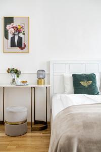 布达佩斯House Beletage-Boutique的白色卧室配有床和鲜花桌