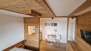 巴塞尔加·迪·皮纳Guest House Dolomiti的木墙和桌椅的房间