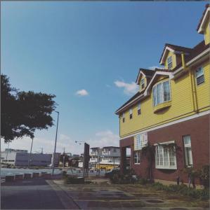 宫古岛宮古島サイクリストの宿的街道边的黄色房子