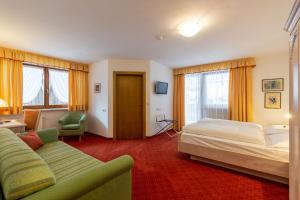 圣坎迪朵思科芬霍夫酒店的酒店客房,配有床和沙发