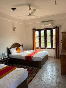 索拉哈Sauraha BnB的一间卧室设有两张床和窗户。