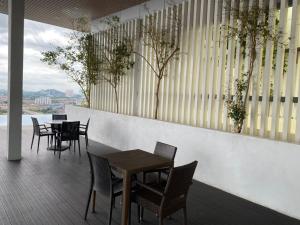 梳邦再也Damen Suite (A) Sunway Subang by DW的阳台餐厅,配有桌椅