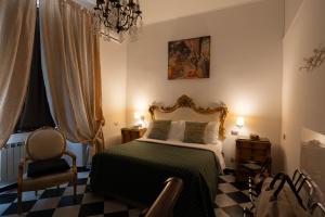 热那亚莫拉利宫酒店的一间卧室配有一张床、一把椅子和一个吊灯。