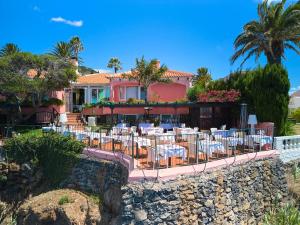 卡尼索Inn & Art Madeira的房屋前设有桌椅的餐厅