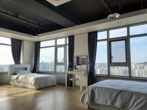 首尔YD公寓酒店的一间卧室设有两张床和大窗户