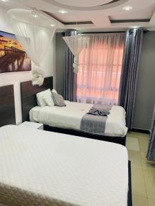 基苏木SR Apartments Milimani, Kisumu的一间卧室设有两张床和窗户。