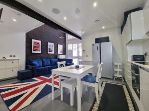 伦敦Deluxe Townhouse Zone 1 Brick Lane的厨房以及带白色桌椅的起居室。