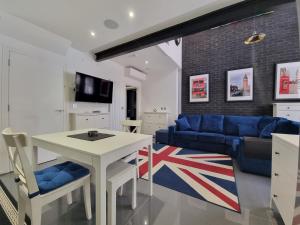 伦敦Deluxe Townhouse Zone 1 Brick Lane的客厅配有桌子和蓝色沙发