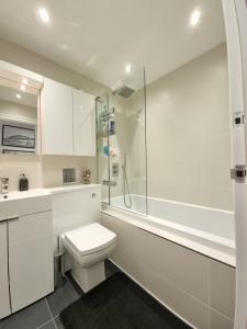 伦敦Deluxe Townhouse Zone 1 Brick Lane的白色的浴室设有卫生间和淋浴。
