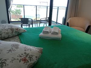 马里利亚Studio 811的绿色的床,上面有两条毛巾