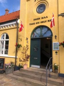 内克瑟Cafebrumman的黄色的建筑,有绿门和两个旗帜