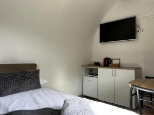 Selnica ob DraviGlamping PEC - All Inclusive light的卧室配有一张床,墙上配有电视。